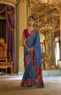 Woman wearing a turquoise blue Viscose Silk saree with luxury print and Marmo finish for weddings and celebrations.