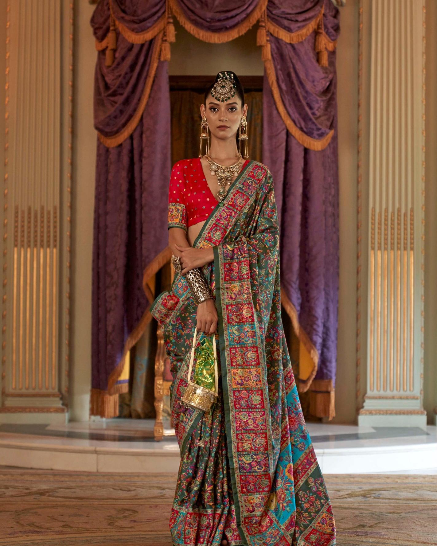 Woman wearing a teal green Viscose Silk saree with luxury floral print and Marmo finish.